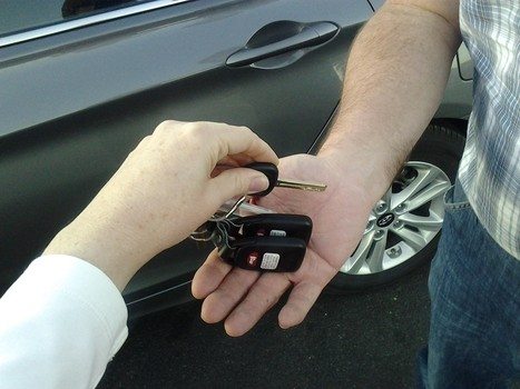 person's hand handing over keys to another person's hand