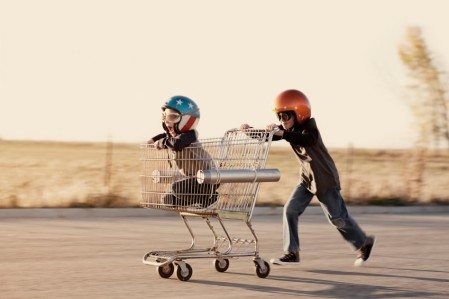 Two kids playing with shopping cart