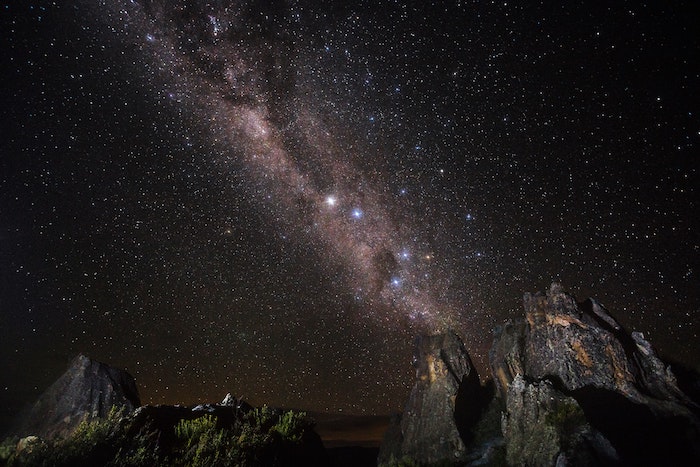 Starry sky atop of rocky outcrop