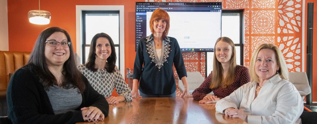 Group of women sitting in front of WordPress dashboard screen